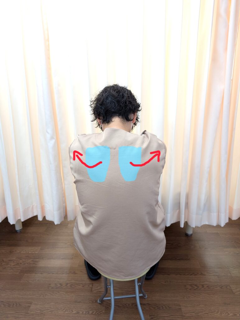 背中を丸めながら肩甲骨を左右に開くストレッチの動き